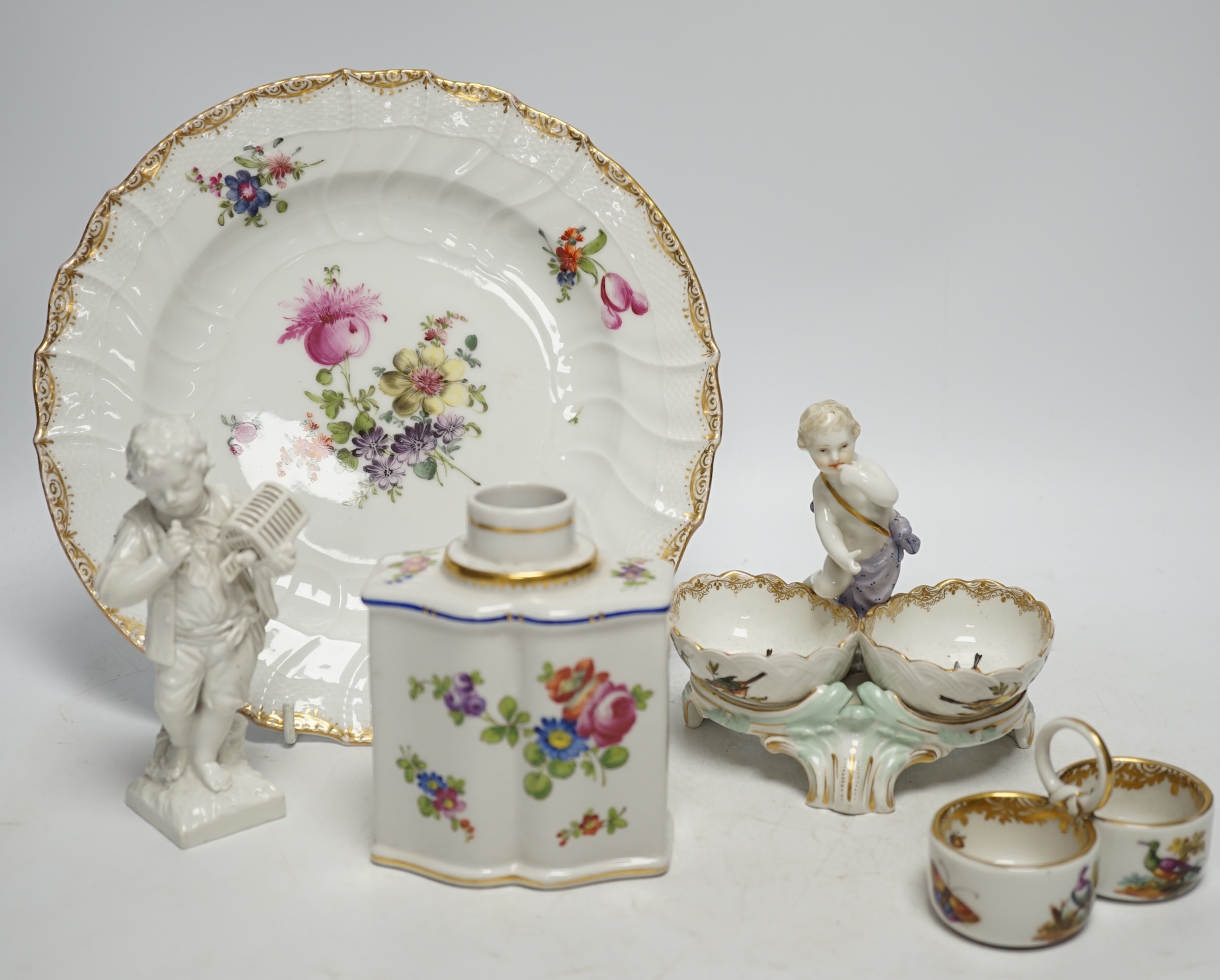 A group of Berlin and German porcelain: a plate, two salts, a figure and a tea canister, tallest figure 13.5cm high. Condition - fair to good.